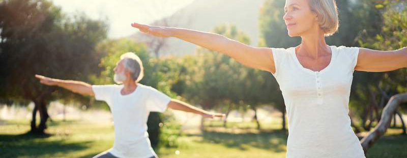 Two adults doing yoga outside