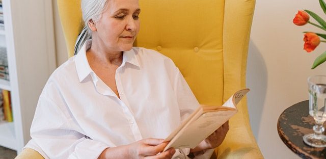Woman on couch reading book